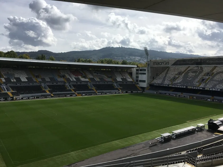 Vista do alto da bancada do Estádio D. Afonso Henriques, em Guimarães, com o relvado vazio e nuvens baixas